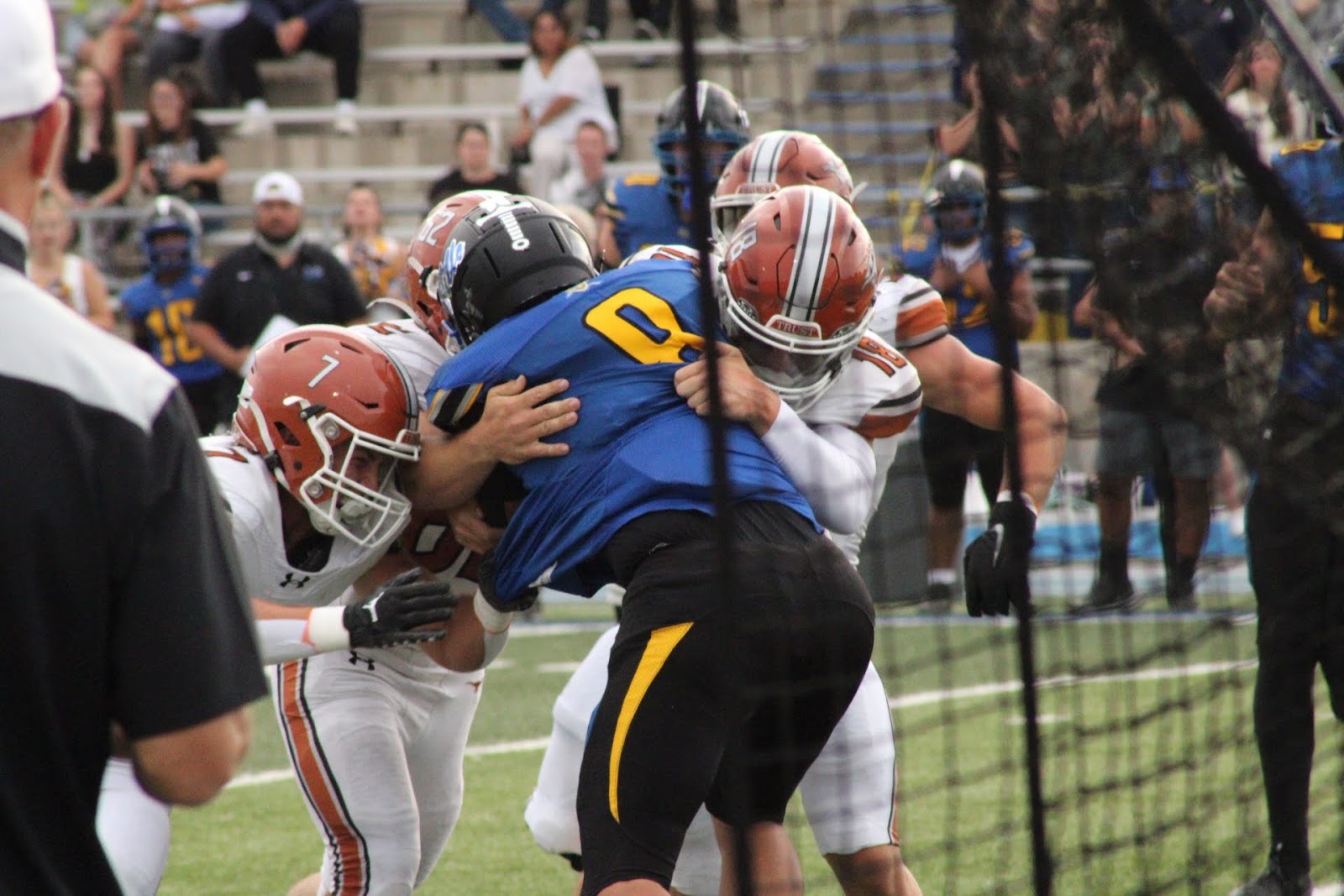 Two football players colliding in a tackle at the line of scrimmage
