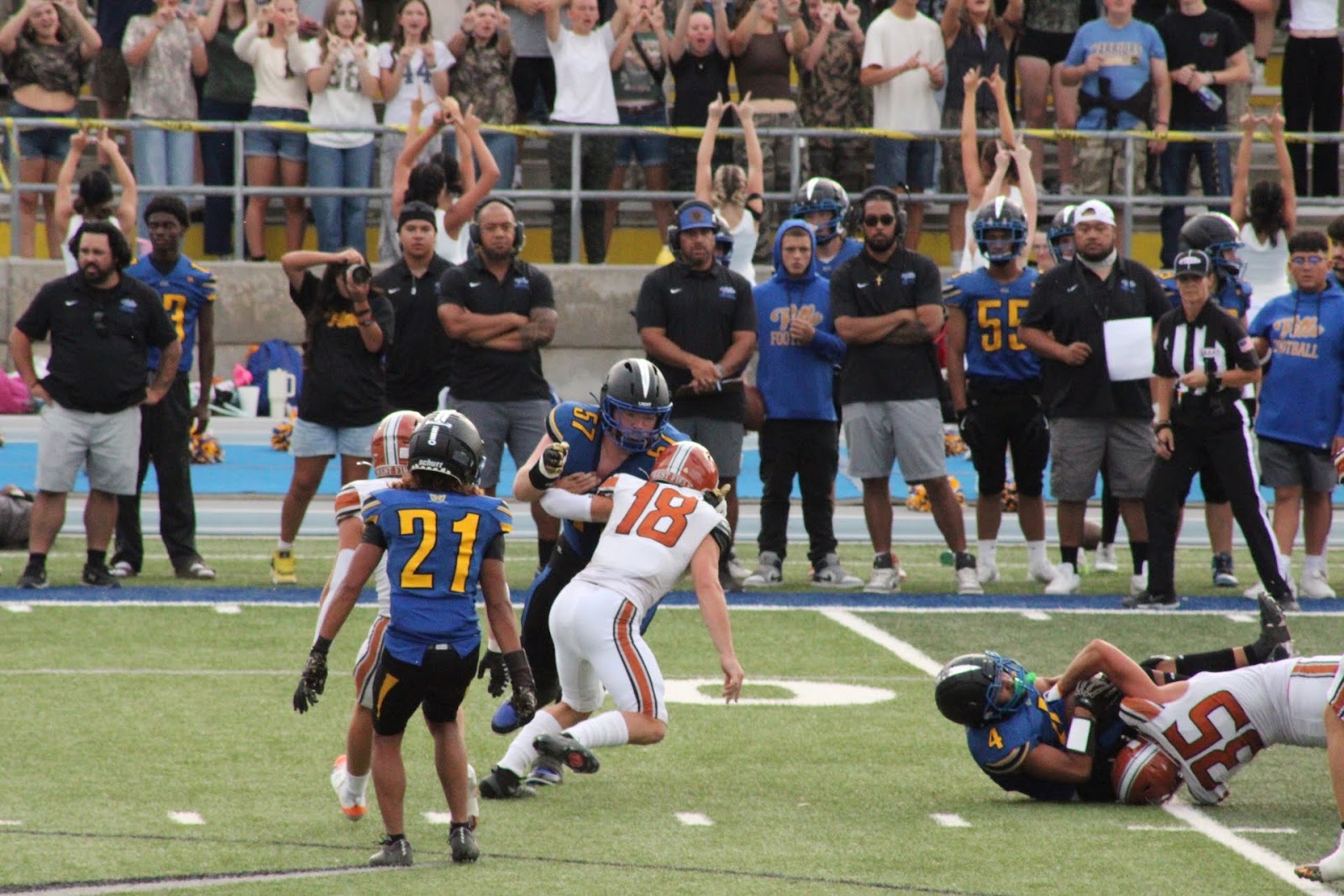 Football player diving for the ball as a defender closes in